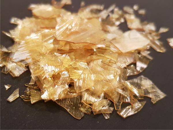 Shellac is produced by Kerria Lacca beetles ("lac bugs") in India and other parts of south east Asia. They feed on tree sap and secrete shellac to make tunnels along the branches. Dewaxed shell flakes